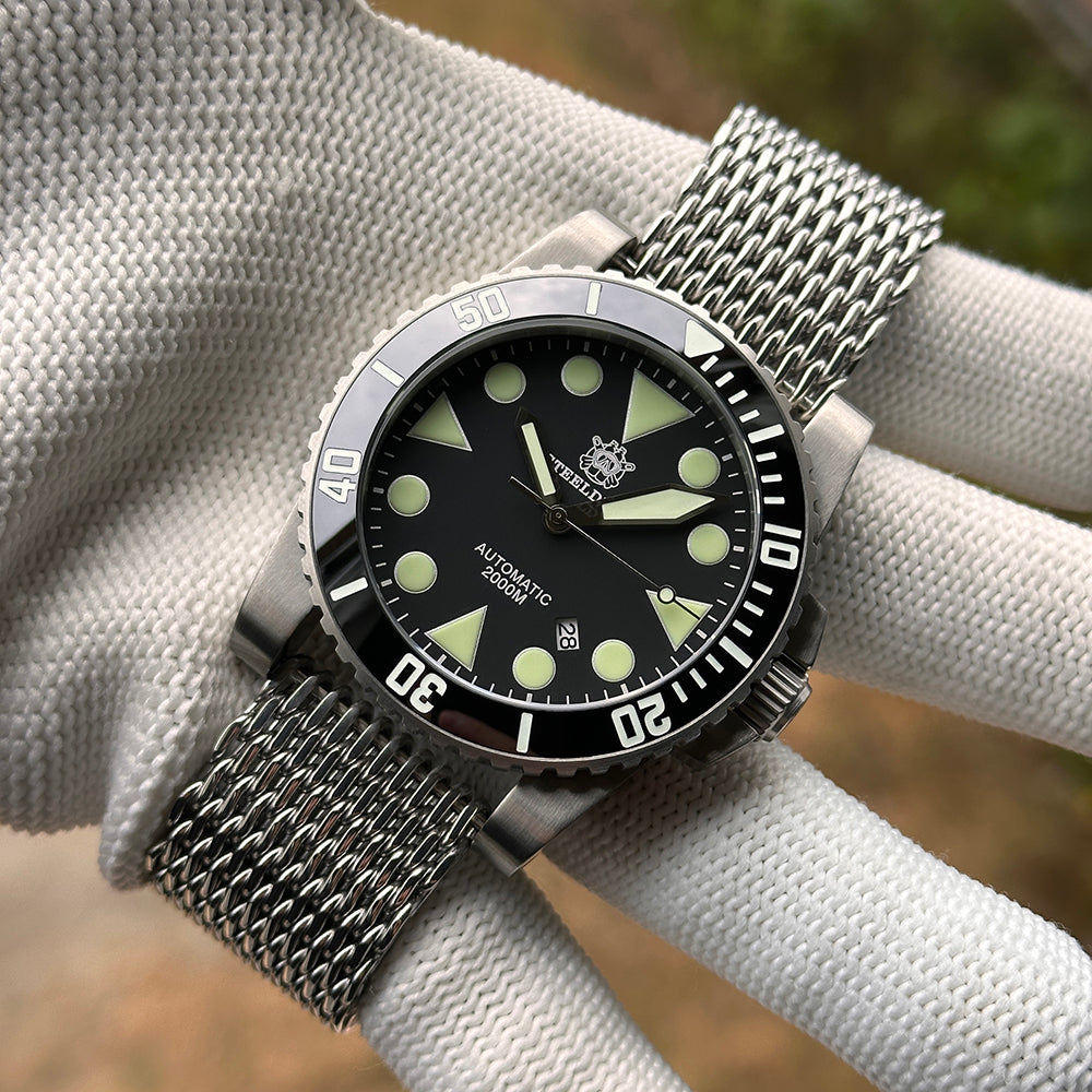 Steeldive SD1987 dive watch shark mesh bracelet on gloved wrist, angled wrist view