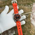Steeldive SD1987 on orange rubber dive strap lifestyle shot in gloved hand outdoors