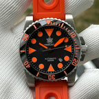 Steeldive SD1987 orange dial diver on orange perforated rubber strap held in gloved hand