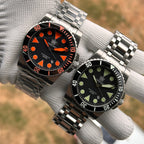 Steeldive SD1987 2000M comparison shot showing orange-dial and green-lume black-dial variants side by side