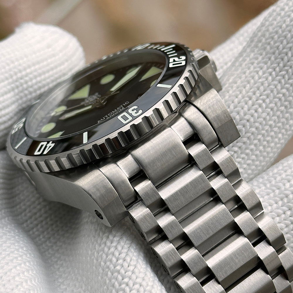 Steeldive SD1987 close-up of stainless steel tank bracelet links and ceramic bezel edge