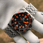 Steeldive SD1987 orange dial variant on tank bracelet held on gloved hand showing full case