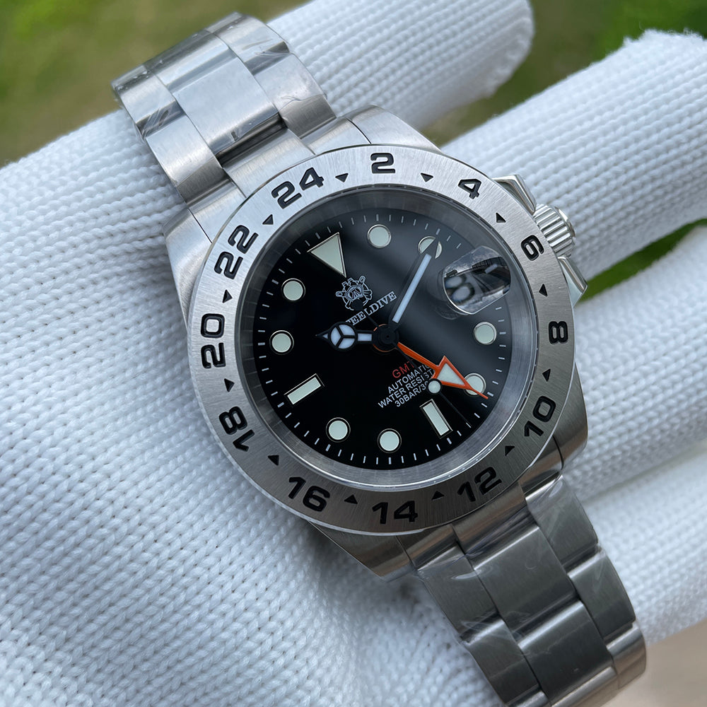 Steeldive SD1992 GMT close-up of black dial, date window and orange GMT hand on oyster bracelet