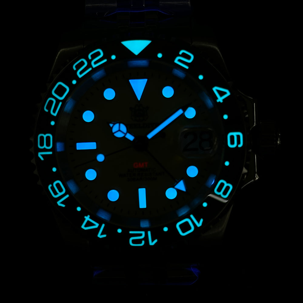 Steeldive SD1993 GMT watch lume shot with bright blue luminous indices and bezel numerals in the dark