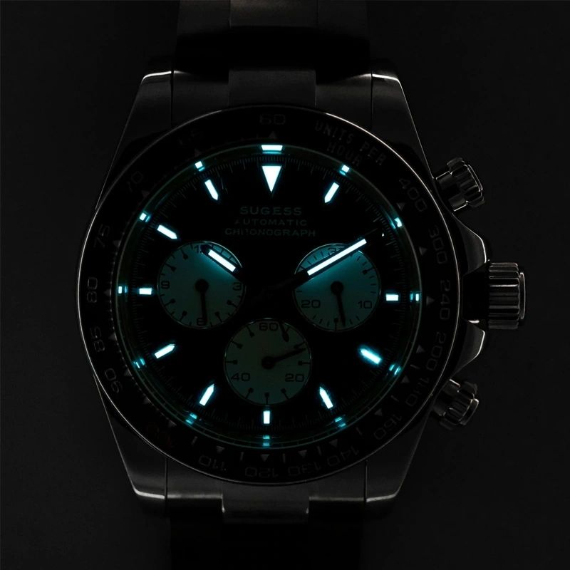 Sugess S418-2 black panda chronograph dial and markers glowing blue-green lume in the dark, close-up