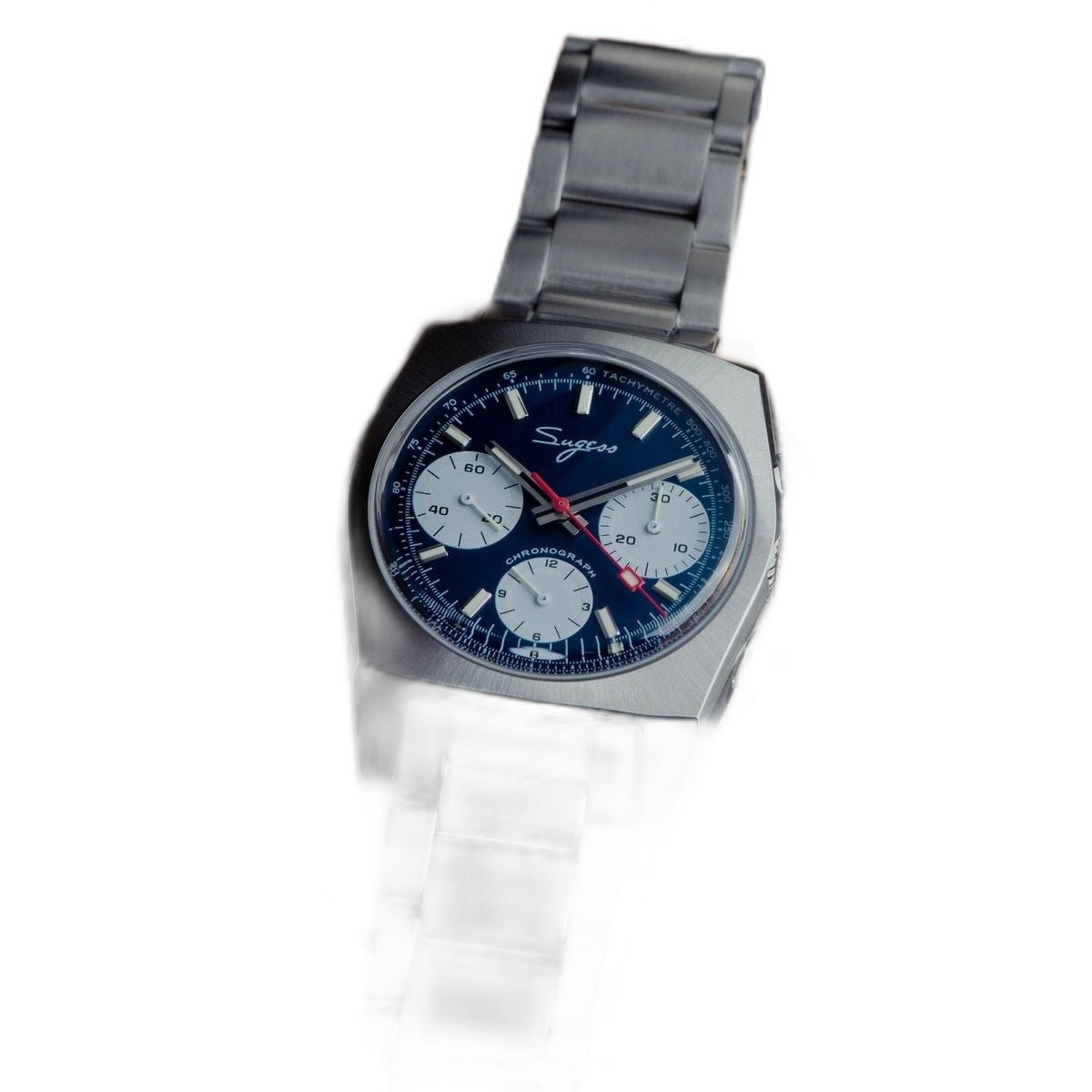 Sugess S419 blue dial, white sub-dials, steel bracelet, angled view beside a camera lens