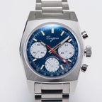 Sugess S419 blue dial, white sub-dials, steel bracelet, angled view on a blue notebook with pen