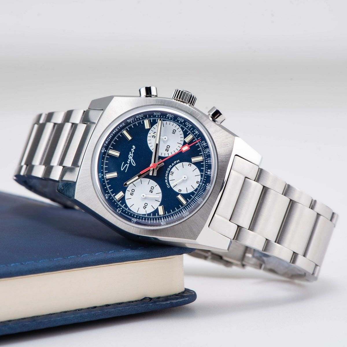 Sugess S419 blue dial with white sub-dials on steel bracelet, dramatic angled product view on blue