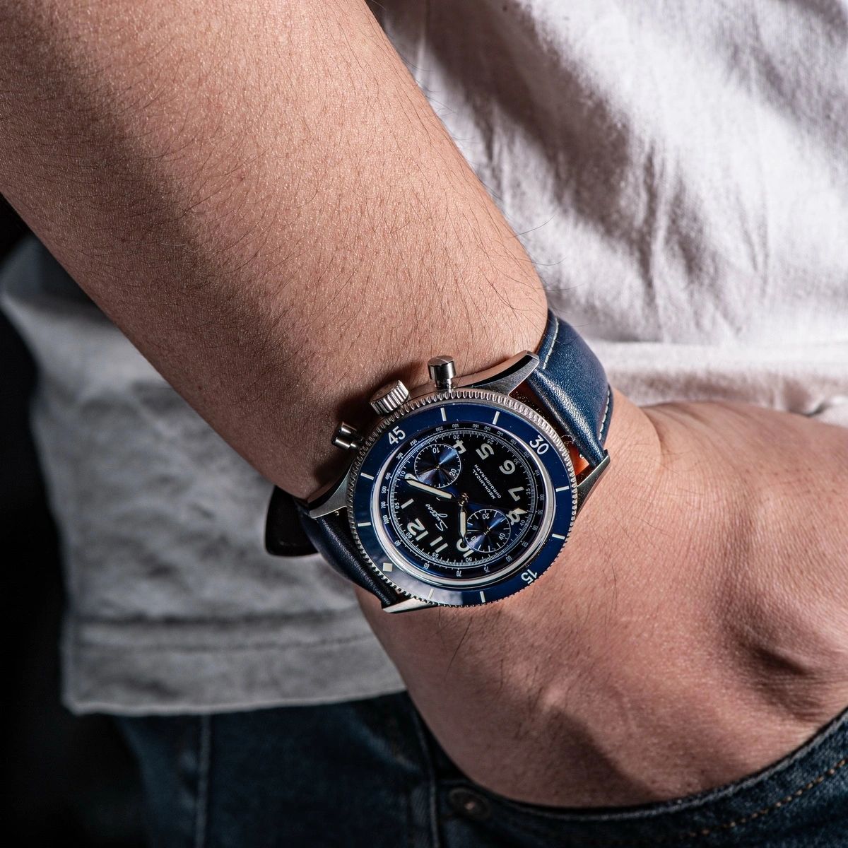 Sugess S423 blue-dial chronograph with blue leather strap worn on a wrist, angled lifestyle view