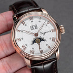 Sugess S437 silver dial moonphase, rose gold case, brown leather strap, angled close-up held in hand
