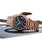 Sugess S449 black mother-of-pearl dial day-date, rose gold case, diamond markers, three-quarter angle on dark stone
