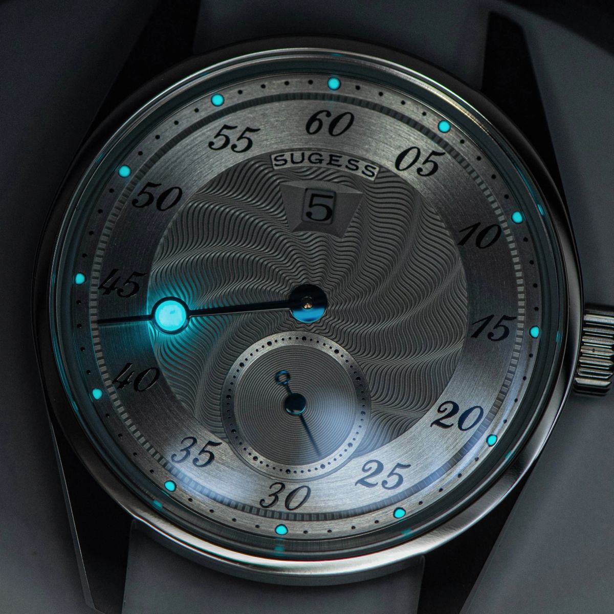 Sugess S451 dress watch guilloche dial glowing blue lume in the dark, offset minute track and sub-seconds, close-up