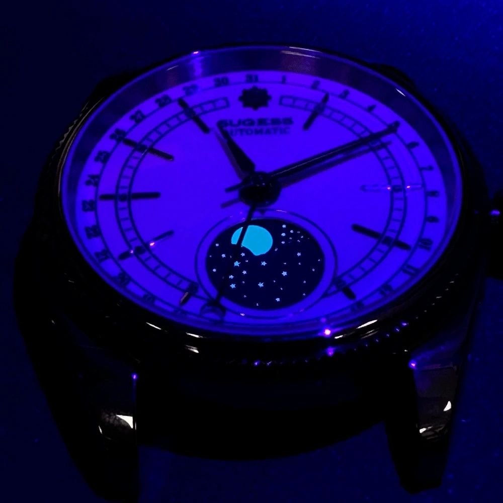 Sugess S452 moonphase dress watch dial glowing blue lume in the dark, moon disc and hands aglow, close-up
