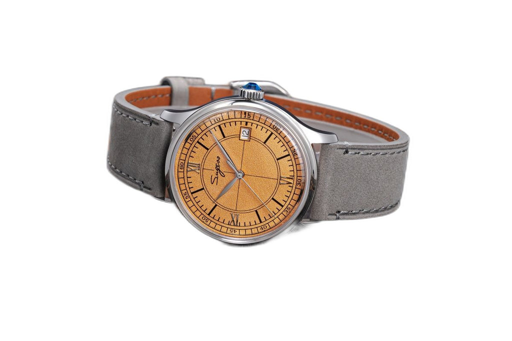 Sugess S455 Art Master salmon frosted dial dress watch, grey suede strap, angled view on dark wood