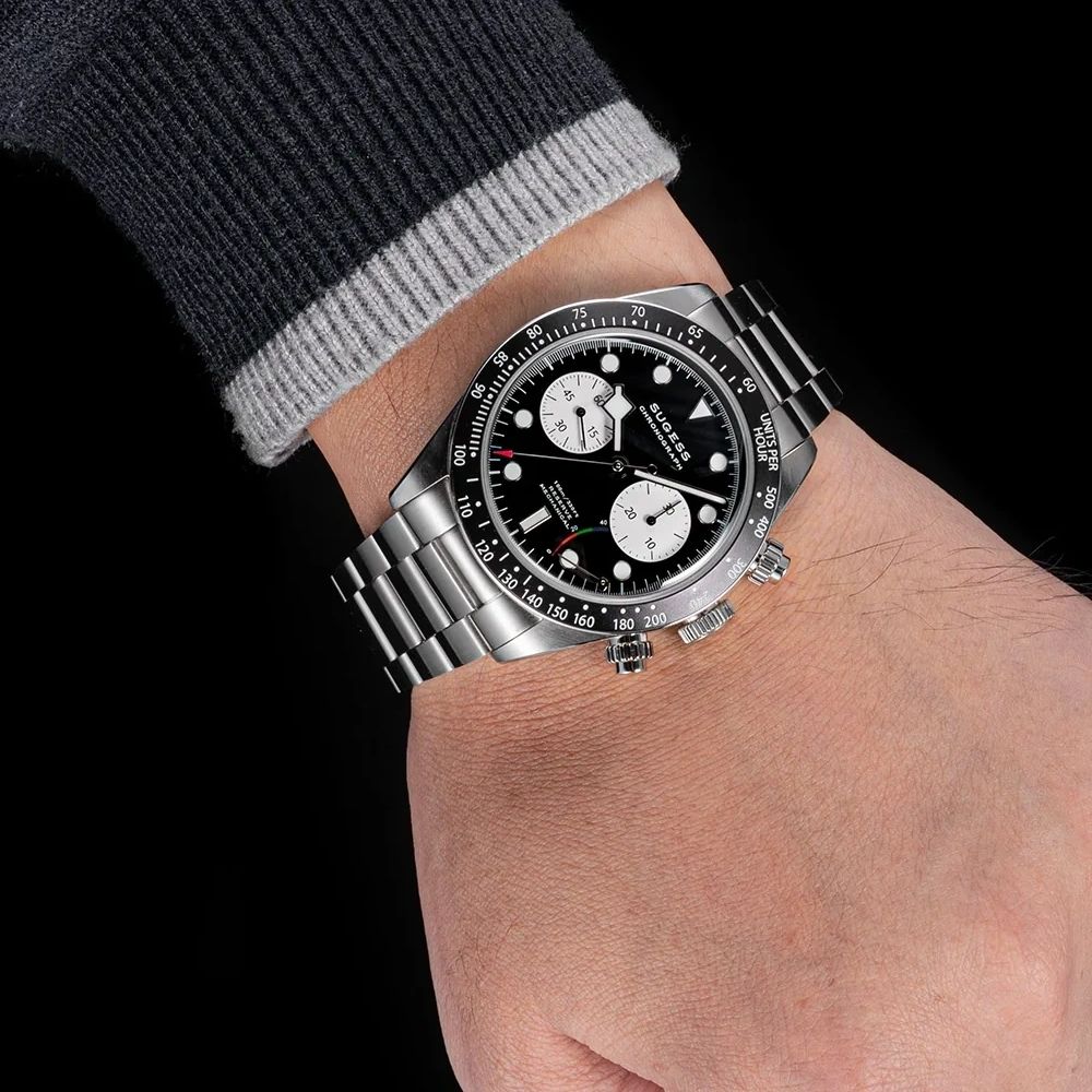 Sugess S457 black dial manual chronograph worn on the wrist with a navy jumper, white sub-dials