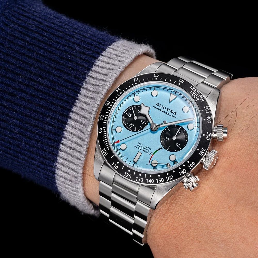 Sugess S457 teal blue dial manual chronograph worn on the wrist with a navy and grey jumper
