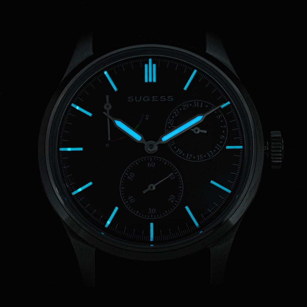 Sugess S458 blue dial power-reserve watch, navy leather strap, three-quarter angled view on black
