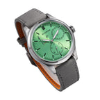Sugess S458 green dial power-reserve watch, grey suede strap, dynamic angled view on black