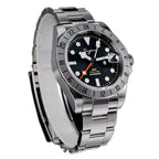 Sugess S463 GMT black dial watch, date cyclops and orange GMT hand, steel bracelet, angled view on black
