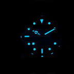 Sugess S463 GMT dial glowing blue lume in the dark, markers, hands and GMT triangle aglow, close-up