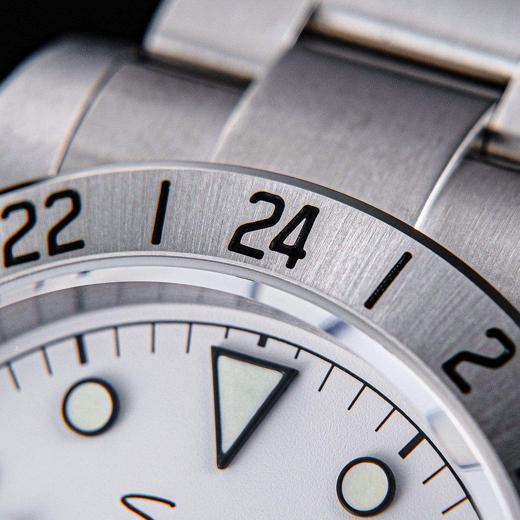 Sugess S463 macro of the fixed 24-hour engraved steel bezel showing 22, 24 and 2, steel oyster bracelet