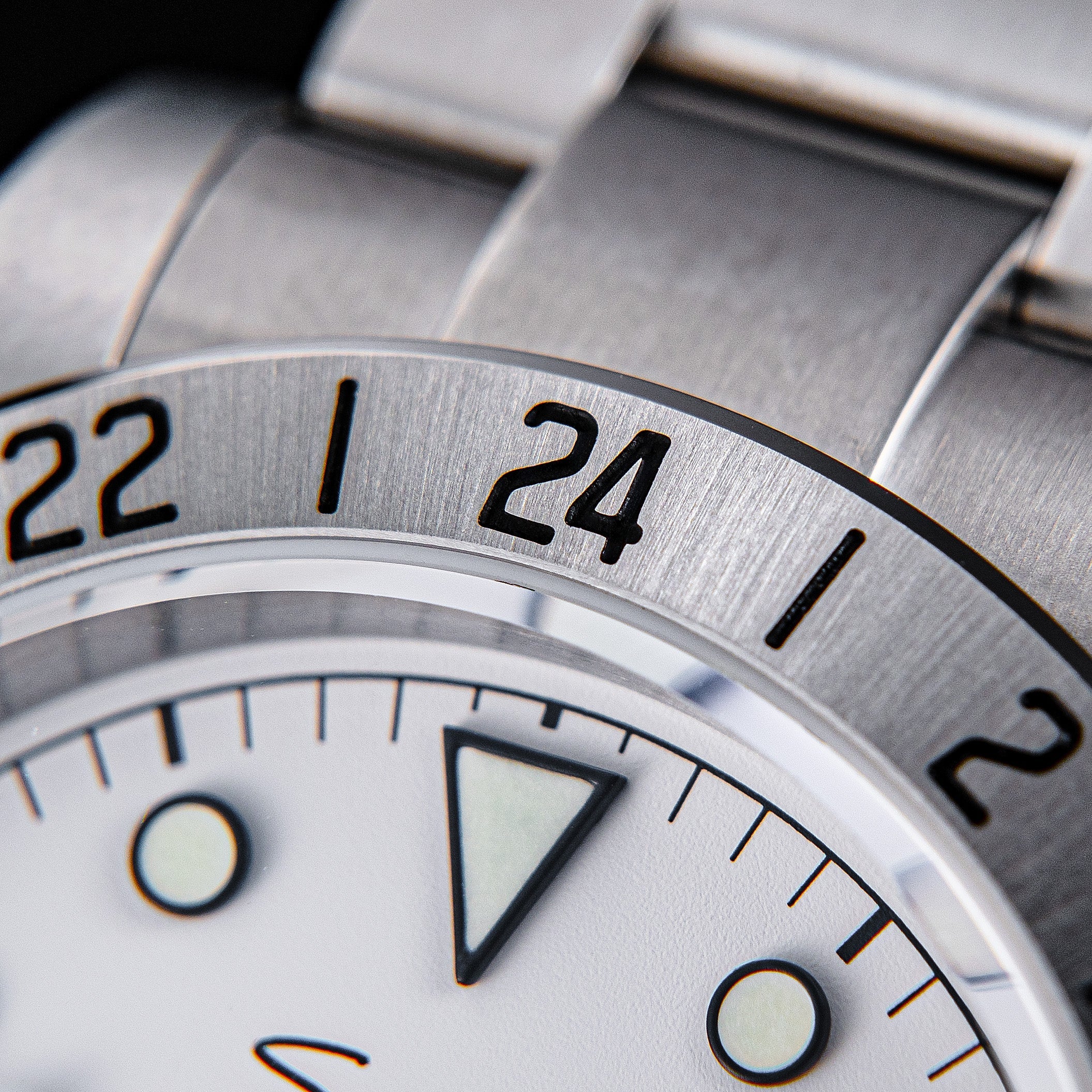 Sugess S463 macro of the fixed 24-hour engraved steel bezel showing 22, 24 and 2, steel oyster bracelet