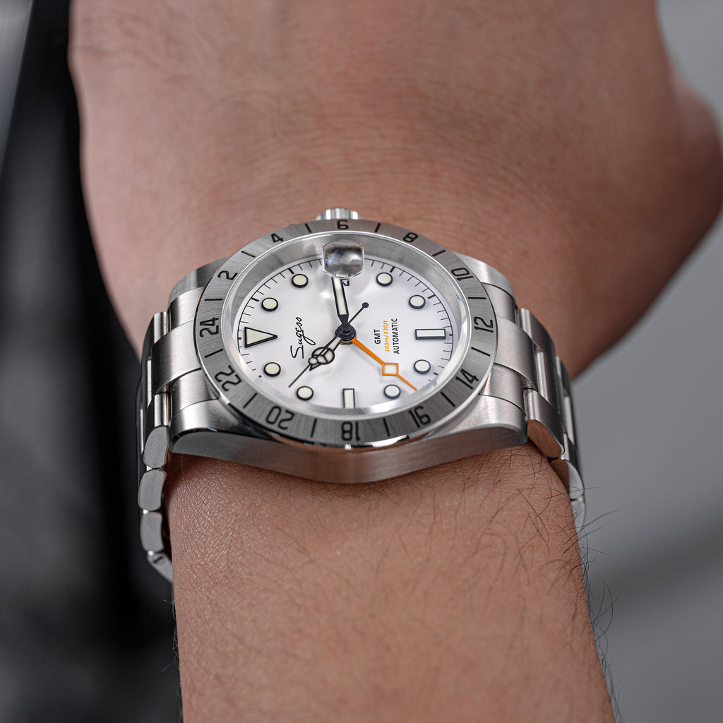 Sugess S463 white-dial GMT automatic watch on the wrist, steel oyster bracelet, grey knit background