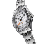 Sugess S463 GMT white dial watch, orange GMT hand, steel bracelet, three-quarter angled view on black