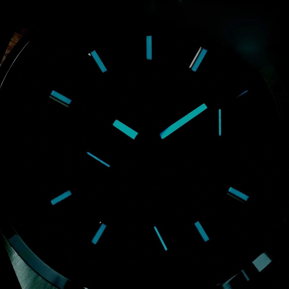 Sugess S465 Chrono Heritage dial glowing blue lume in the dark, applied markers and hands aglow, close-up