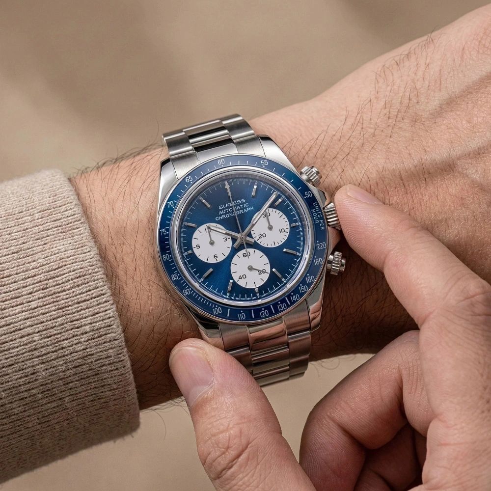 Sugess S473 Chrono Racing blue dial automatic chronograph worn on the wrist with a beige sweater, steel bracelet