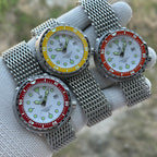 Three STEELDIVE SD1975N watches with yellow, orange and red bezels on steel mesh bracelets